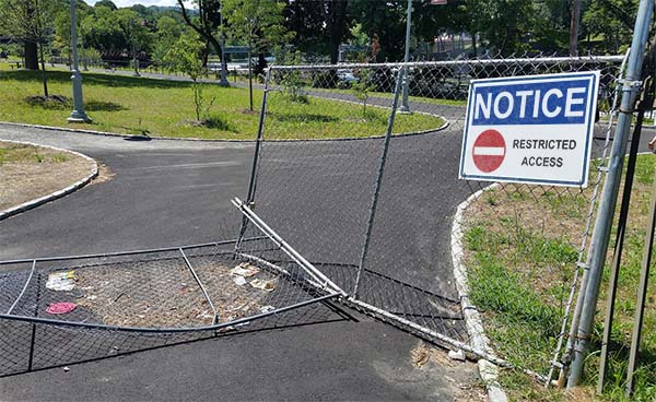 broken entrance gate with Notice - Restricted Access sign