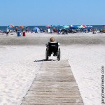 woman in wheelchair at end of path on the beach